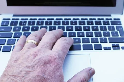 A hand typing on a laptop keyboard Stock-Fotos
