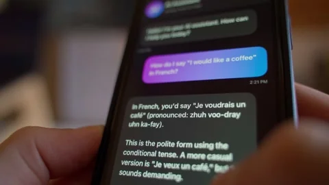 Hand typing question to AI chatbot assistant on smartphone for language 库存影片 339761465