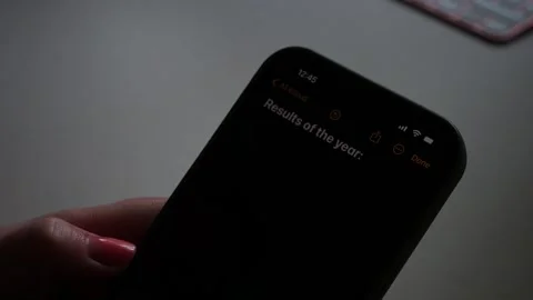 Hand typing year end results in the notes on a smartphone Stock Footage 296244189