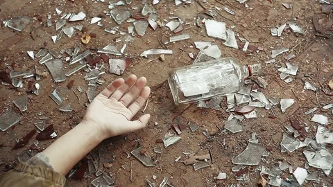 Hand of unconscious person falling on floor, spilling vodka from bottle Stock Footage 80718357