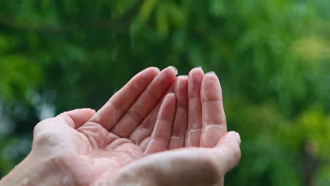 Hand under the rain, rainwater close-up. Woman putting her hand out to feel r Stock Footage 87753775