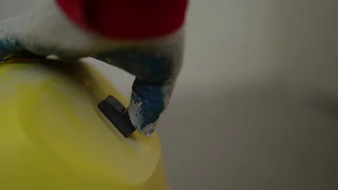 Hand of an unknown builder in a construction glove turns on a yellow industrial Video stock 162195529