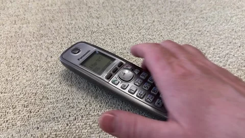 Hand of an unknown person takes the receiver of a Panasonic home radiotelephone Stock Footage 270409183