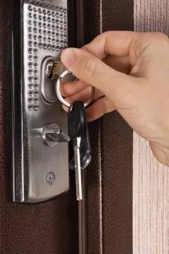 Hand unlocking the door Stock Photos