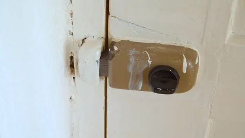 Hand unlocking old anti break in door lock on white door. Stock Footage 130118304