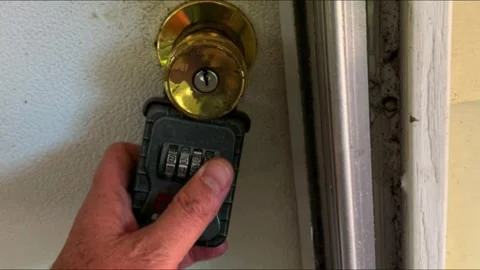 Hand Unlocking Real Estate Lockbox on House Door to Access Property Key Vidéo 343529691