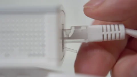Hand unplugging internet cord to wireless router. Hand unplug ethernet cable  Stock Footage 169017492