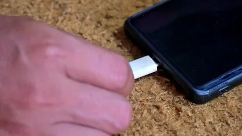 Hand Unplugging White Charging Cable from Smartphone Stock Footage 328577230
