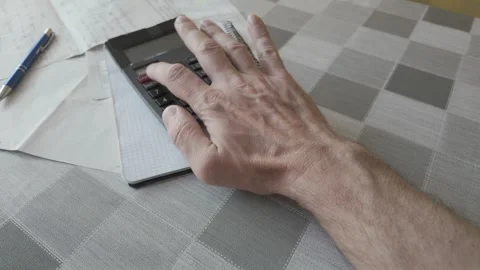 Hand of unrecognizable man adding up living costs and utility charges 库存影片 335508285