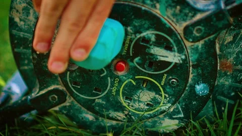 Hand of unrecognizable man plugging lawn mower into outdoor extension socket Stock Footage 314827396