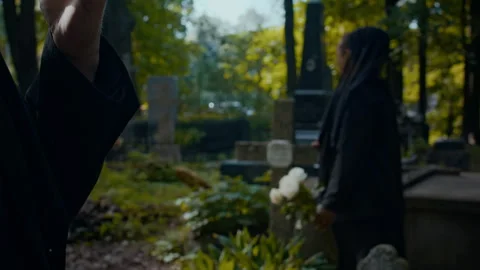 Hand of Unrecognizable Man Smoking Cigarette during Visit to Cemetery with Wife Stock Footage 286204241