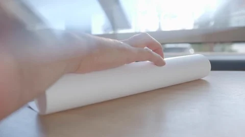  Hand unrolls a roll of paper Stock Footage 117578567
