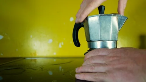Hand unscrews a mocha coffee maker to insert coffee powder to prepare a typical Stock Footage 98248756