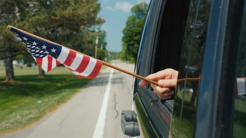 Hand with US flag in a car window. Travel Scandinavia Concept Stock Footage 116025346