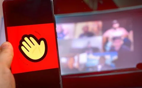 Hand use videoconference app icon of Houseparty . Stock Photos