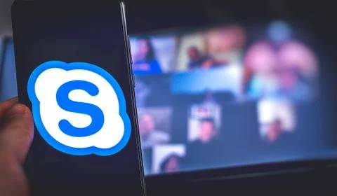 Hand use videoconference app icon of Skype for Business on smartphone. Stockfoto's