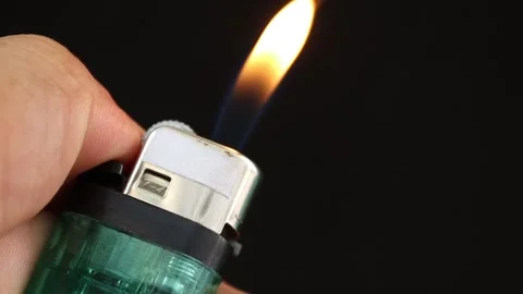 Hand used lighter to light on black background Stock Footage 139905286