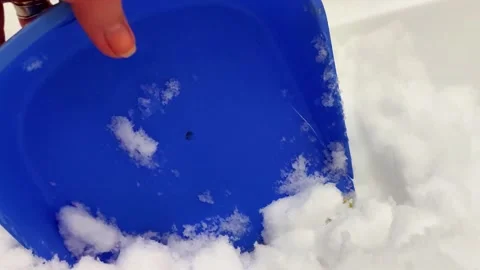 Hand Uses Blue Plastic Scoop to Move Through Packed Snow or Ice Stock-Footage 328906027