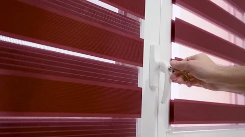 The hand uses keys to closed the balcony door. Window handle lock. Home safety Vidéo 150965430