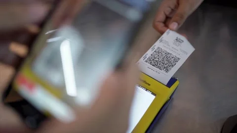 Hand uses mobile phone app to scan a QR code in a store and pay for goods Stock Footage 249793786