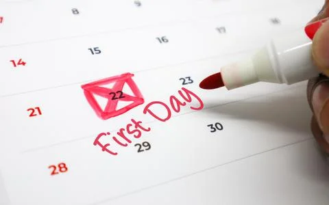 A hand uses a red marker to highlight an important date on a calendar, sign.. Stock Photos