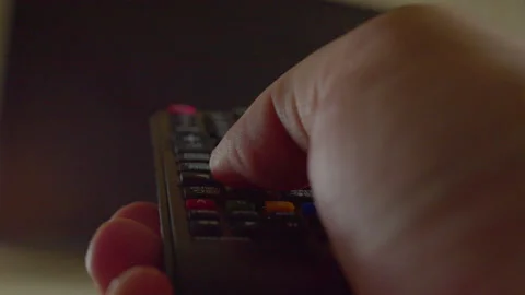 Hand uses a remote control to change the content on a modern TV Stock Footage 335649468