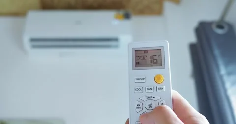 A hand uses remote control technology lower air conditioner temperature.This Stock Footage 270416612