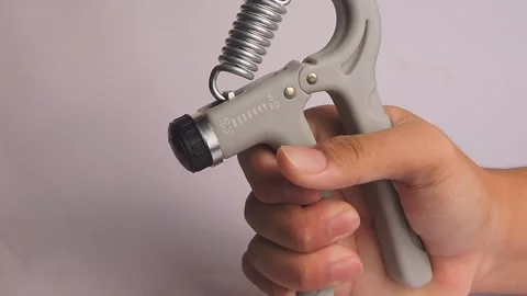 Hand Using Adjustable Grip Strengthener for Exercise Stock Footage 300311838