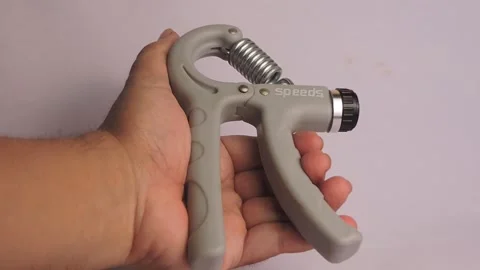 Hand Using Adjustable Grip Strengthener for Exercise Stock Footage 300311842