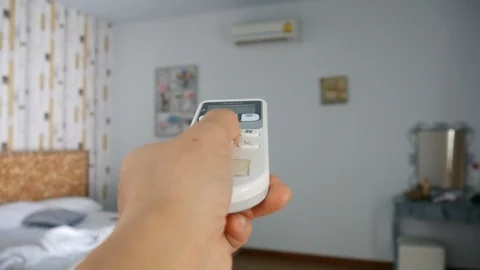 Hand using air condition remote control at home. Stock Footage 92317336