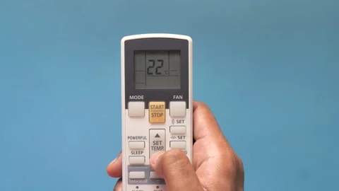 Hand using air conditioner remote control to adjust temperature down on a b.. Stock Footage 333030849