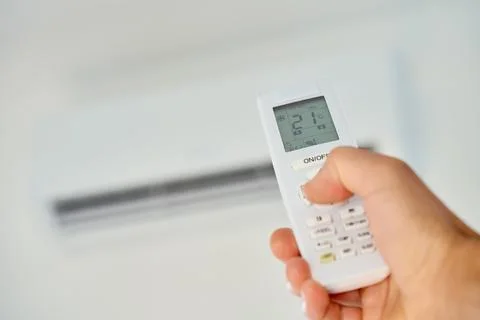 Hand using air conditioner remote control Stock Photos