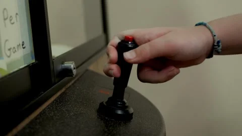 Hand Using Arcade Joystick with Red Button on Game Cabinet Close-Up Stock Footage 324832114