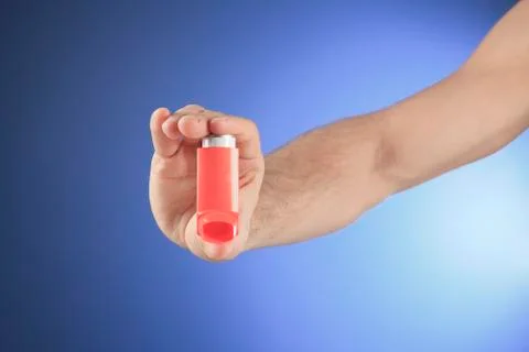 A hand using an asthma inhalator Stock Photos