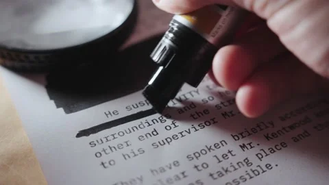 Hand using black marker to censor text on sensitive secret document or memo Stock Footage 199974027