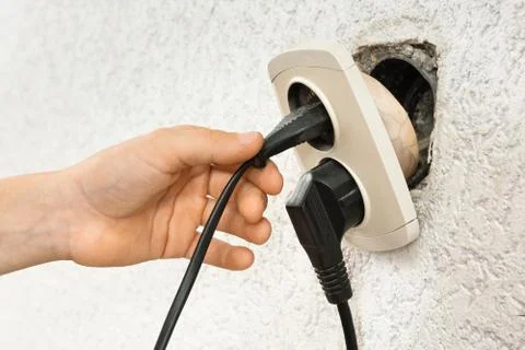 Hand using broken electric socket Stock Photos