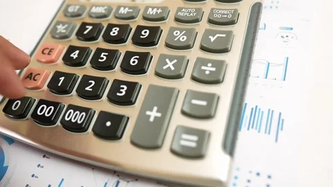 Hand Using Calculator on Financial Charts Stock Footage 320724941
