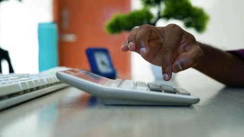 Hand using calculator at office desk, Close-up of a person's hand using a c.. Stock Footage 346459995