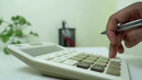Hand Using Calculator with Pen on Desk, Close-up of a hand using a calculat.. Stock Footage 317737423