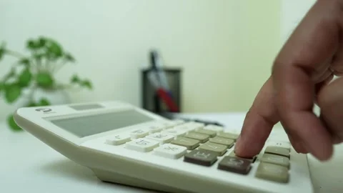 Hand Using Calculator with Pen on Desk, Close-up of a hand using a calculat.. Stock Footage 317737428