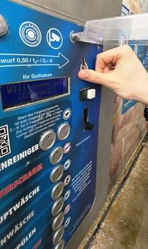 Hand using car wash payment machine with clear instructions displayed Stock Photos