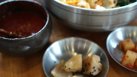 Hand using chopstick and spoon mixing bibimbap Korean iconic food dish Stock Footage 95215721