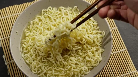 Hand using chopstick picking hot soup ramen noodle. Top view. Instant noodles Stock Footage 281669942