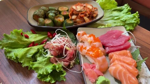 Hand using chopsticks pick Sushi and Sashimi rolls on the glass table. Fresh Stock Footage 317808839