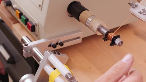 Hand using coil winding machine - reeling conducting wire and insulating tape Video stock 139744414