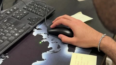 Hand using computer mouse beside keyboard in modern office workspace Stock Footage 333187896