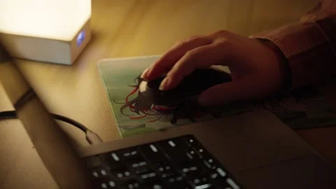 Hand Using Computer Mouse Beside Laptop in Warm Home Workspace Stock Footage 344948090