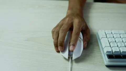 Hand using a computer mouse beside keyboard, Close-up of a hand using a whi.. Stock Footage 347859214