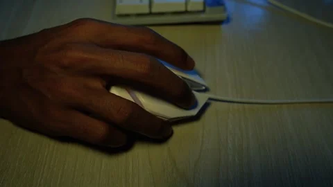 Hand using computer mouse at dim desk, Close-up of a hand using a wired com.. Vídeo Stock 345119163
