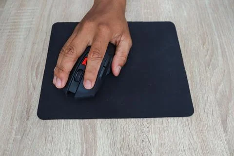 Hand Using A Computer Mouse On A Wooden Desk Stock Photos